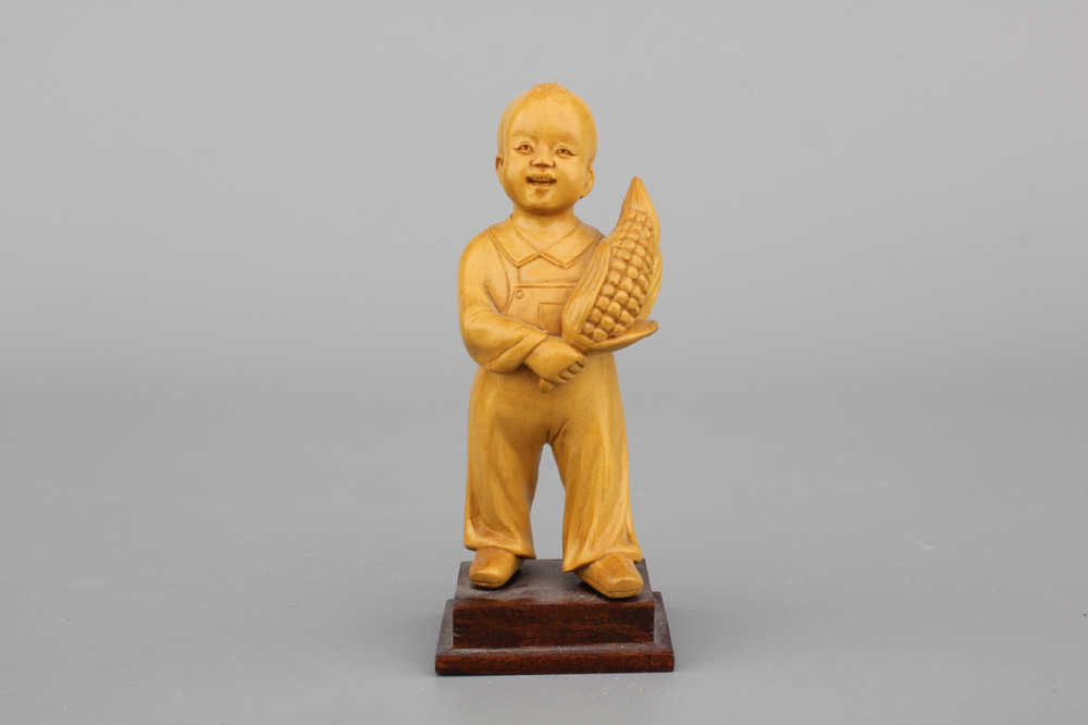 A Chinese carved wood figure of a boy with corn, Cultural Revolution, 20th C.