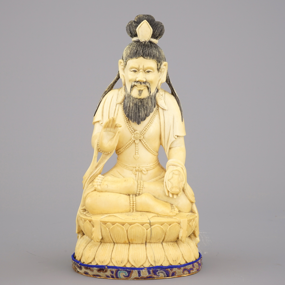 A Chinese carved ivory figure of a seated Luohan, 19/20th C.