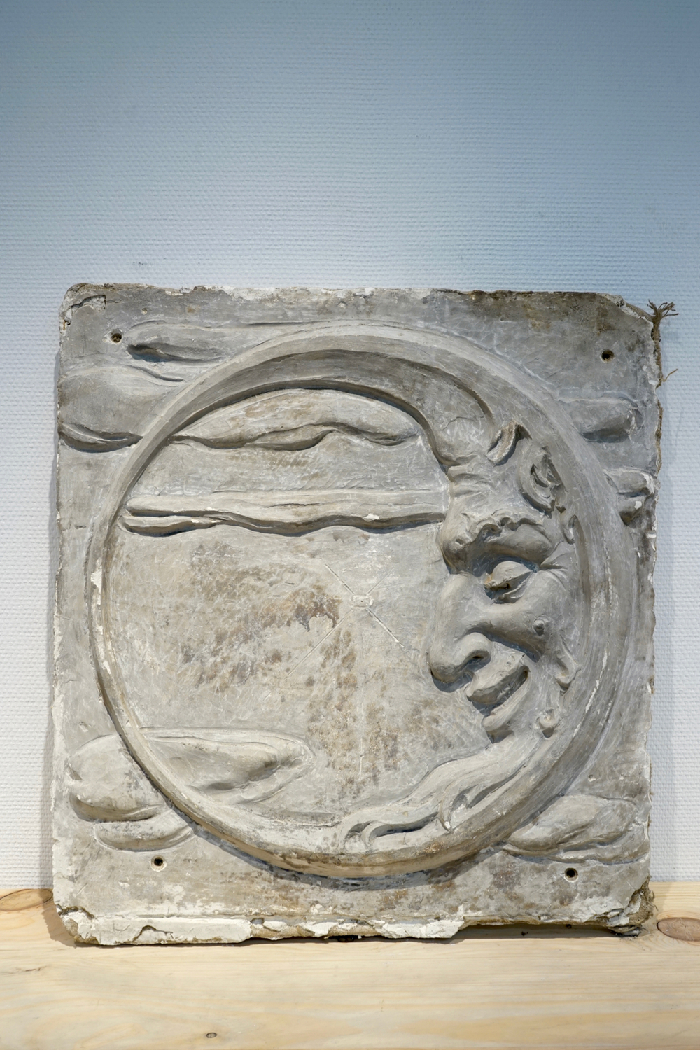 A plaster cast of a brewery advertising sign depicting the moon, 19/20th C., Bruges
