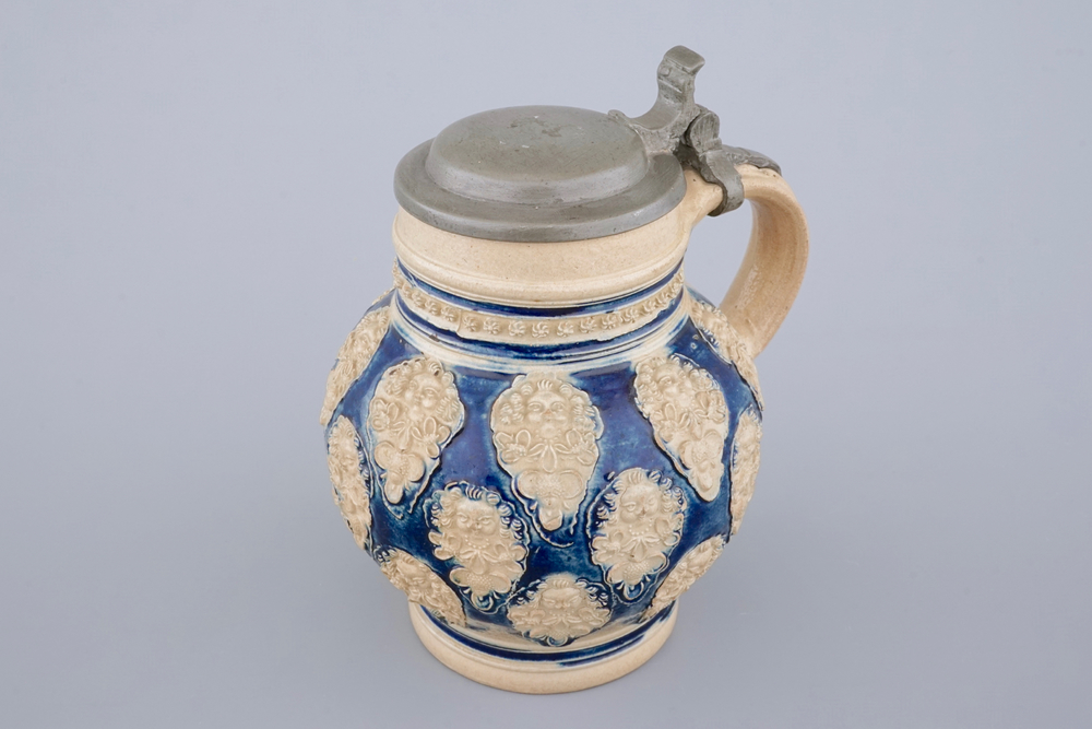 A globular Westerwald stoneware jug with applied masks, 17th C.