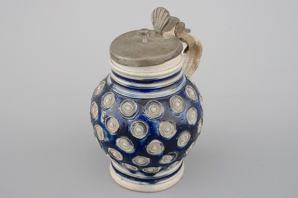 A globular Westerwald stoneware jug with appliques and pewter lid, dated 1689