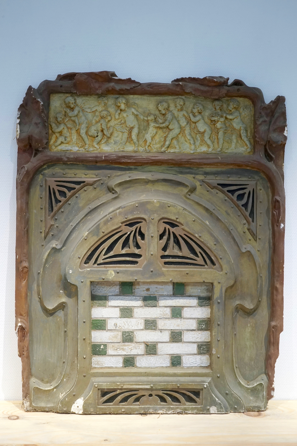 A plaster cast of an art nouveau fireplace front with cherubs, 19/20th C., Bruges