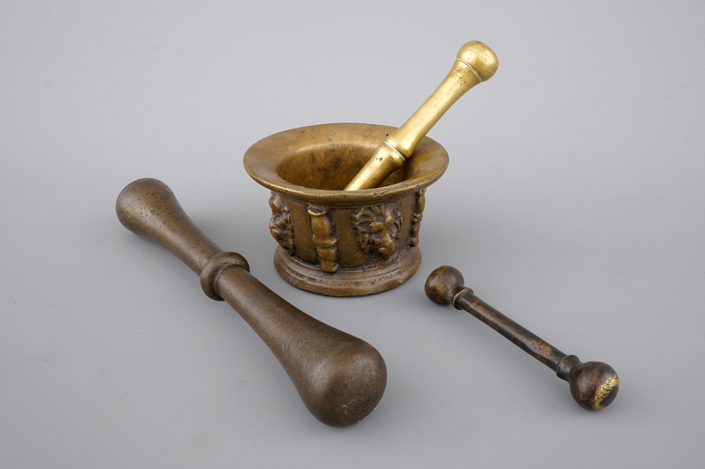 A bronze mortar with lion's heads and 3 various pestles, 17th C.