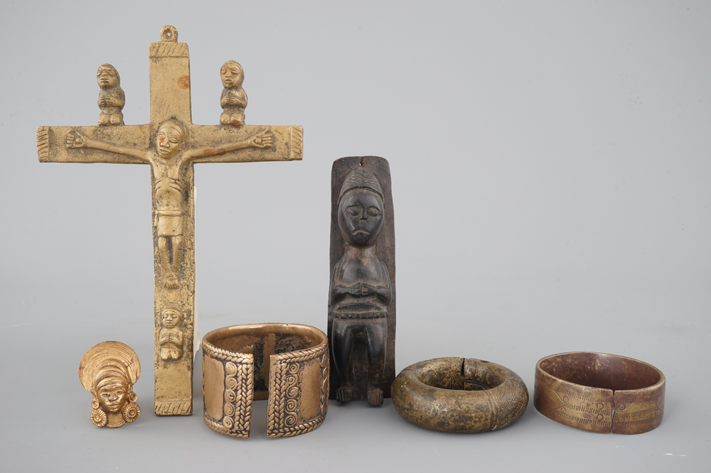 A selection of African bronze bracelets, a crucifix and carved wood figure, 19/20th C.