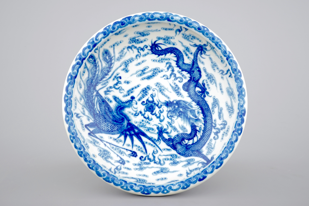 A blue and white Chinese porcelain shallow bowl with a dragon and a phoenix, 19/20th C.