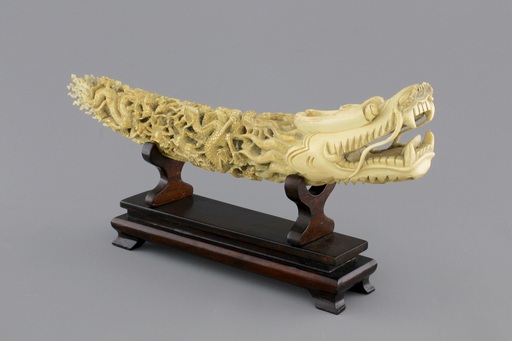A Chinese ivory carving of a dragon on wooden stand, early 20th C.