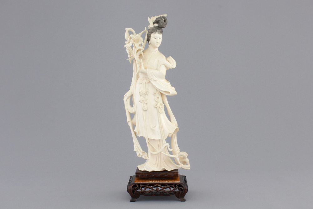 A finely carved Chinese ivory lady on wooden stand, ca. 1900