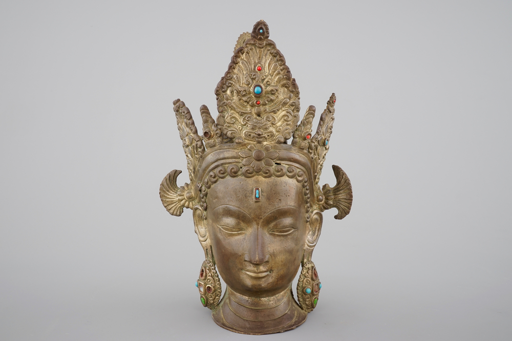 A tall gilt bronze head of a Boddhisatva with semi-precious stones, Tibet, 17/18th C.
