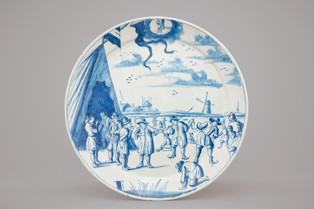 A Dutch Delft blue and white plate with skaters from the 'Zodiac' month series, early 18th C.
