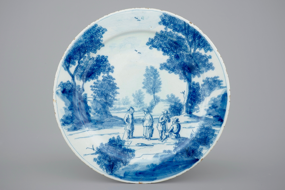 Une assiette raffin&eacute;e en Delft bleu et blanc d'un paysage anim&eacute; de personnages, 18e