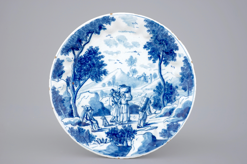 A fine Dutch Delft blue and white fluted plate with travellers in a landscape, 18th C.