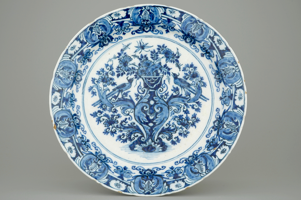 A Ducht Delft blue and white dish with birds around a vase, 18th C.