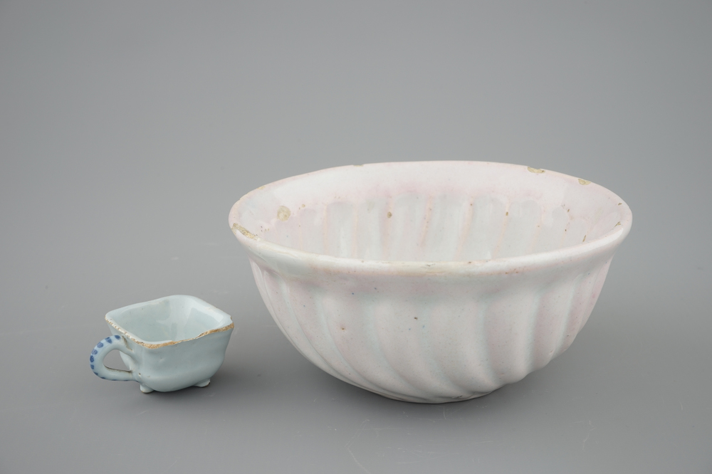 A white Dutch Delft baking mold and a miniature cup, 18th C.