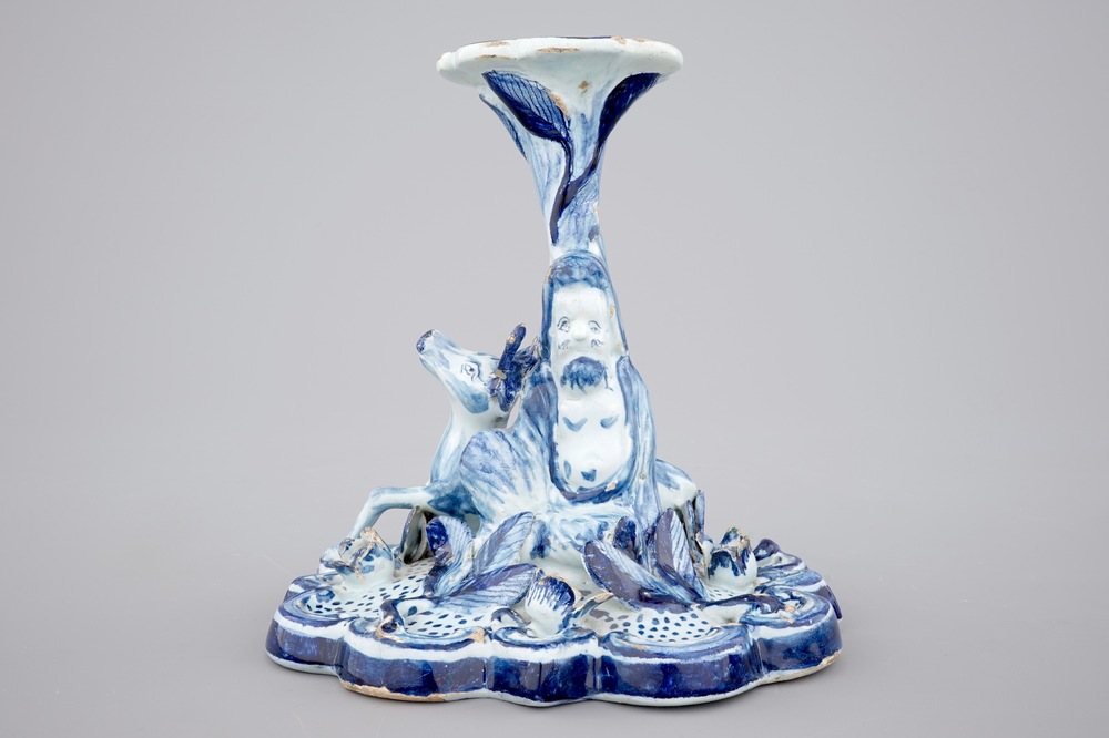 A blue and white Dutch Delft candlestick with a deer and a buddhist, 18th C.