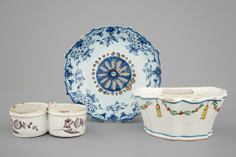 A Dutch Delft strainer, a wall flower holder and a cruet stand in French faience, 18th C.