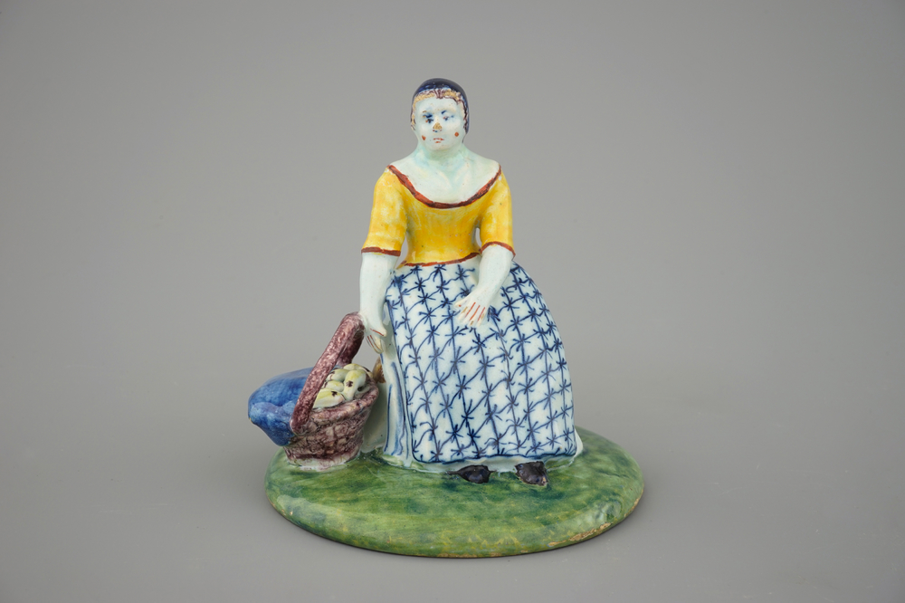 A polychrome Dutch Delft figure of a lady selling fish, 18th C.