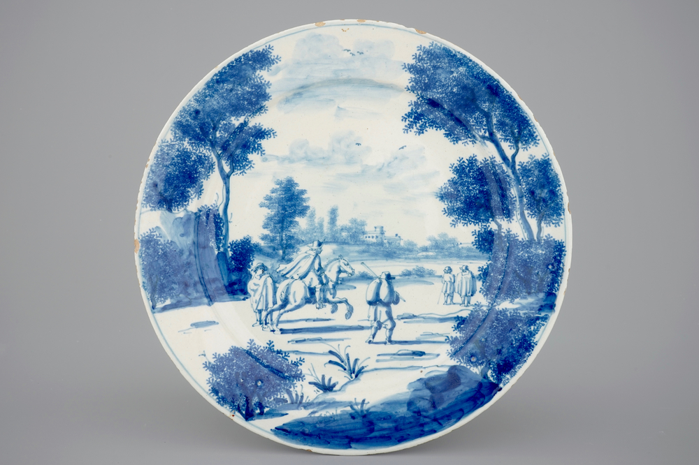 Une assiette raffin&eacute;e en Delft bleu et blanc d'un paysage anim&eacute; de personnages, 18e