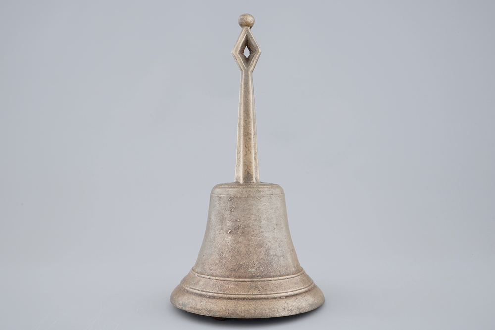 A tall bronze table bell with stylised handle, 16/17th C.