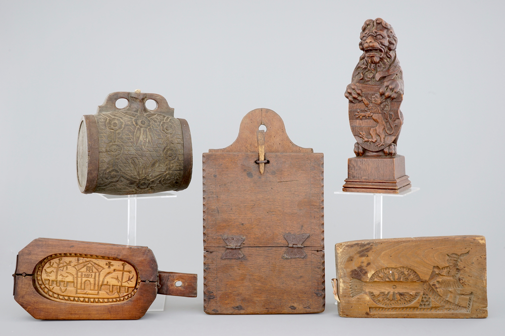 Various wood objects: a lion of Bruges, a butter mold, a cookie mold, a school bag and a wine jug, 18/20th C.