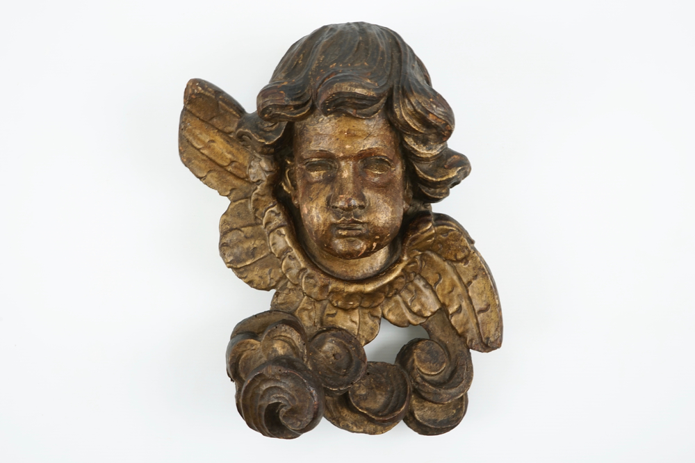 A large carved and gilt wood putto head, 17th C.