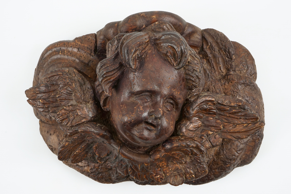 A large carved and patinated wood putto head, 18th C.