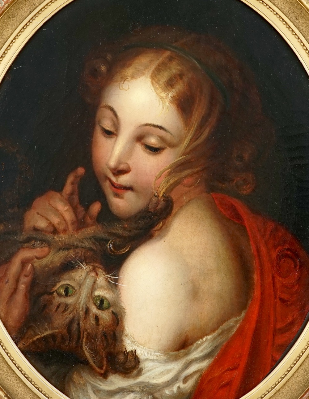 Een portret van een meisje met een kat, olie op doek in verguld ovalen kader, 18/19e eeuw