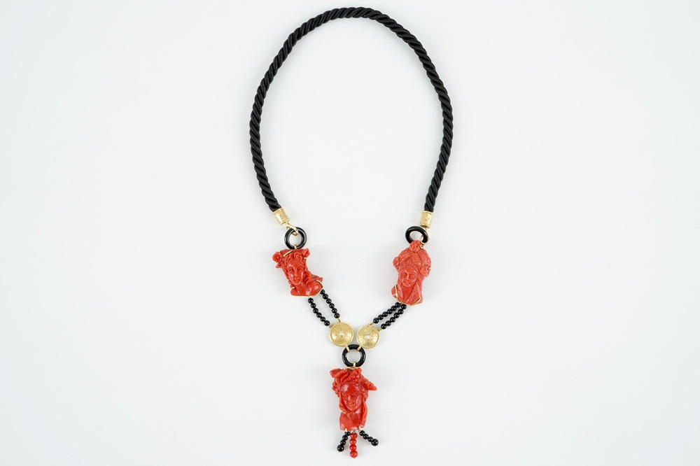 A necklace with three carved coral figures, Italy, 20th C.