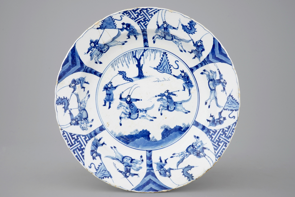 Un plat en porcelaine de Chine bleu et blanc aux guerriers &agrave; cheval, Kangxi