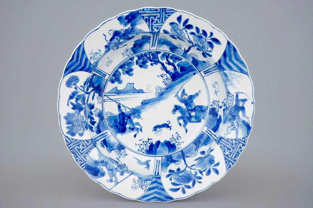 A deep Chinese blue and white plate with a battle scene on horseback, Kangxi