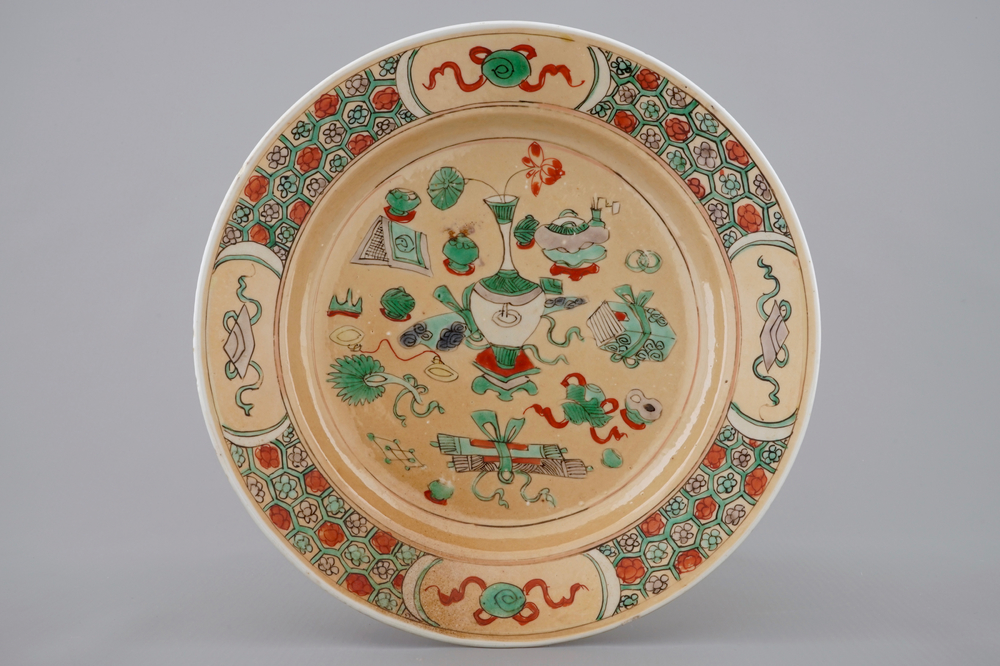 A Chinese famille verte caf&eacute; au lait ground plate with precious objects, Kangxi