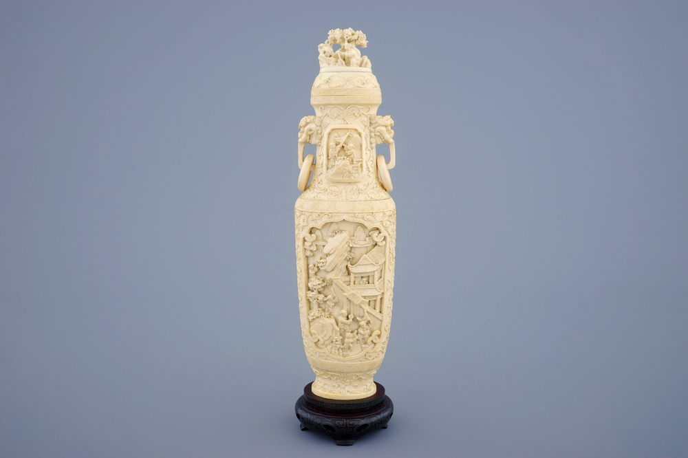 A Chinese carved ivory vase and cover on a wooden base, early 20th C.