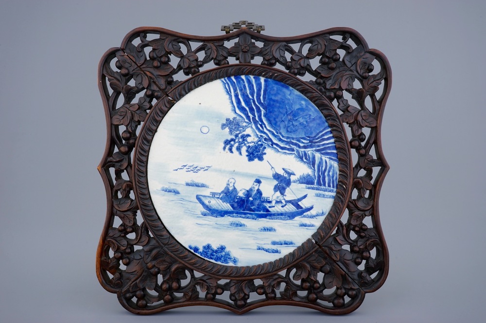 Une plaque en porcelaine de Chine bleu et blanc en cadre sculpt&eacute;, 19&egrave;me