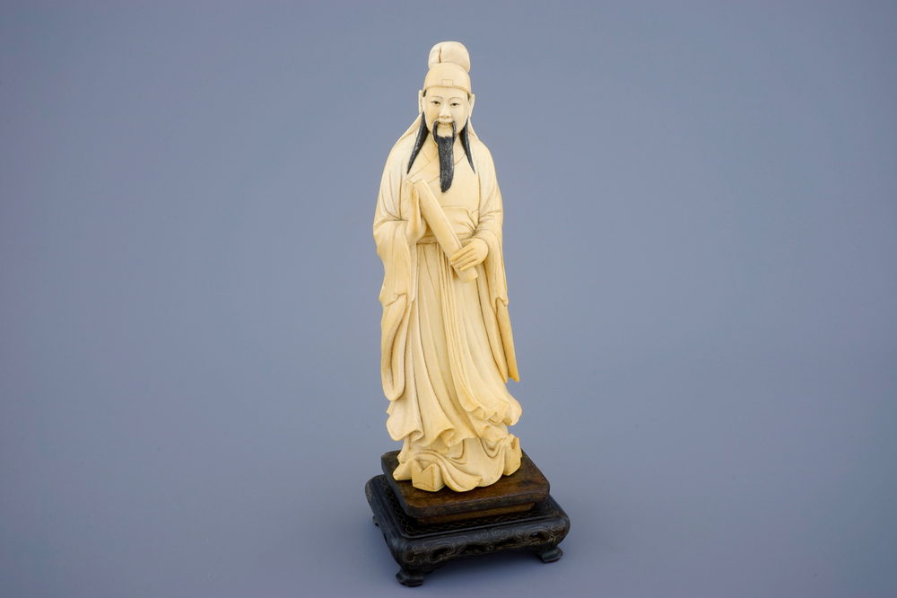 A Chinese ivory figure of a sage with a parchment roll on stand, late 19th C.