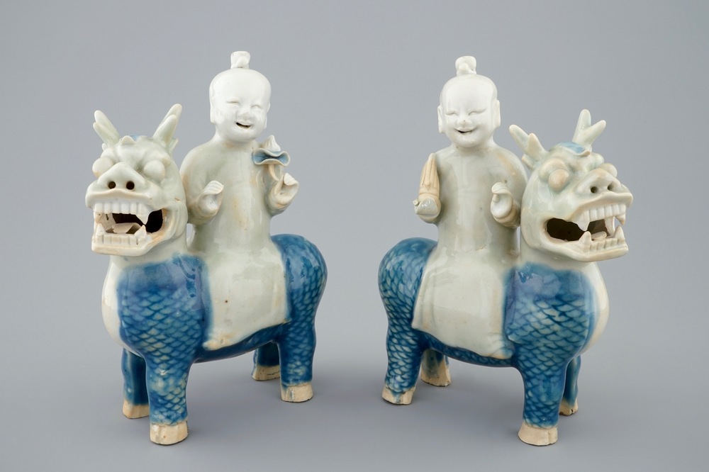 A pair of Chinese celadon, blue and white figures of the Immortal Twins, Hehe Erxian, riding a kylin, 18th C