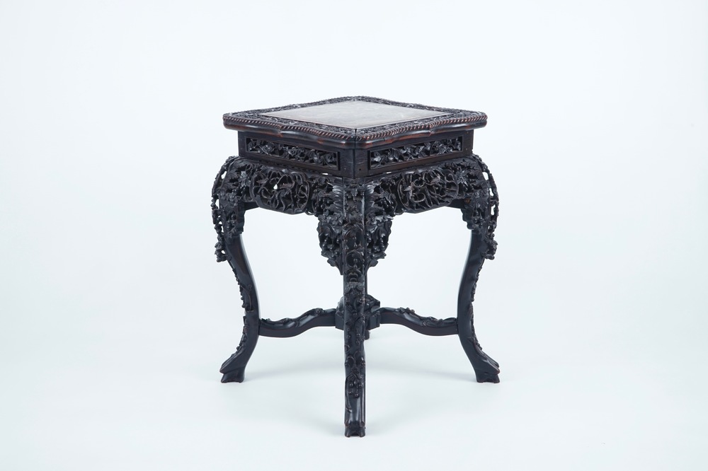 An intricately carved square Chinese wood stand with marble top, 19th C.