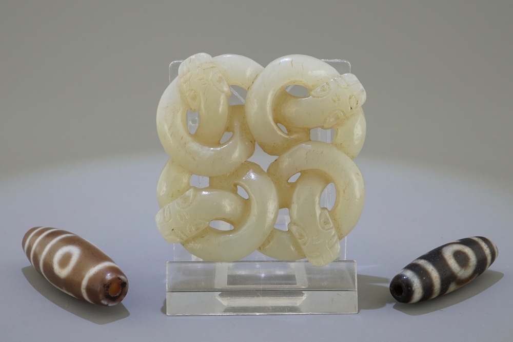A Chinese pale celadon jade carving of snakes and two beads, 19/20th C.