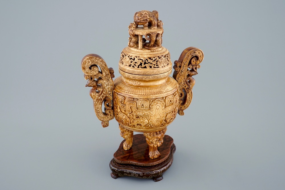 A Chinese carved ivory tripod censer on wooden base, 19th C.