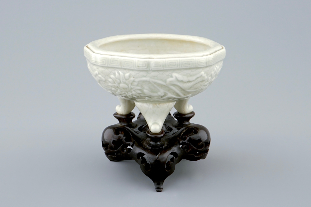 An octagonal Chinese celadon tripod censer on carved wooden base, impressed Qianlong mark, 19th C.