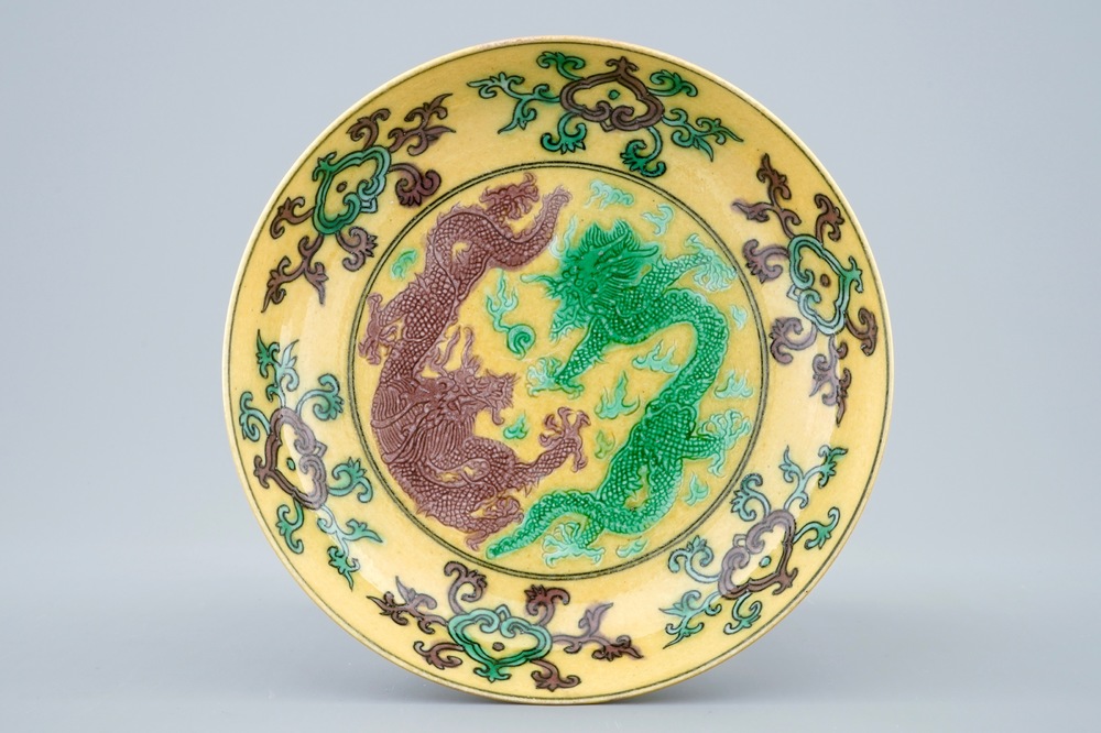 A Chinese yellow-ground saucer with incised green and aubergine dragons, Kangxi mark, 19/20th C.