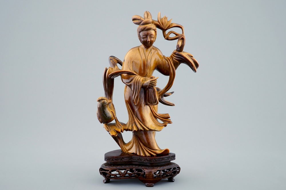 Une figure de Guanyin en pierre oeil de tigre sculpt&eacute;e sur socle en bois, 19/20&egrave;me