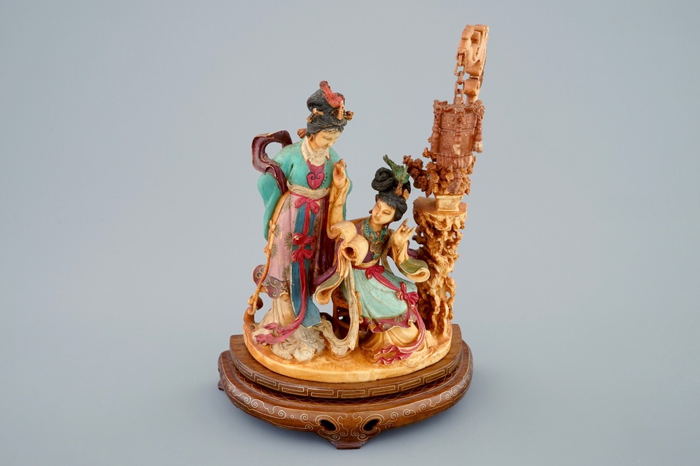 A Chinese polychrome carved ivory group on wooden base, 19th C.