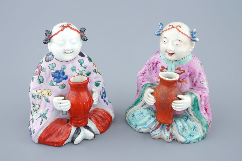 A pair of Chinese famille rose groups of seated boys holding a vase, 18/19th C.