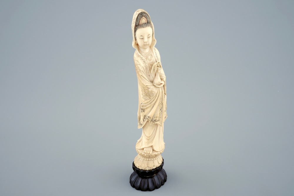 A Chinese carved ivory figure of Guanyin on a wooden base, 19th C.