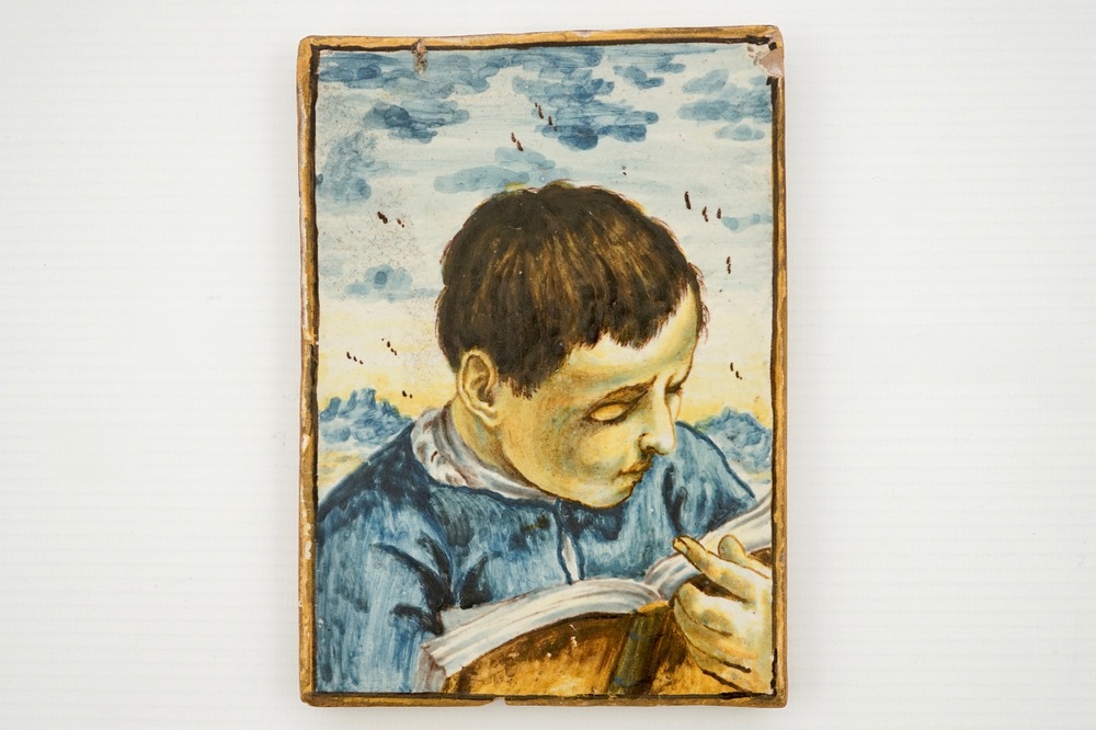 A small Italian Castelli plaque with a reading boy, 17/18th C.