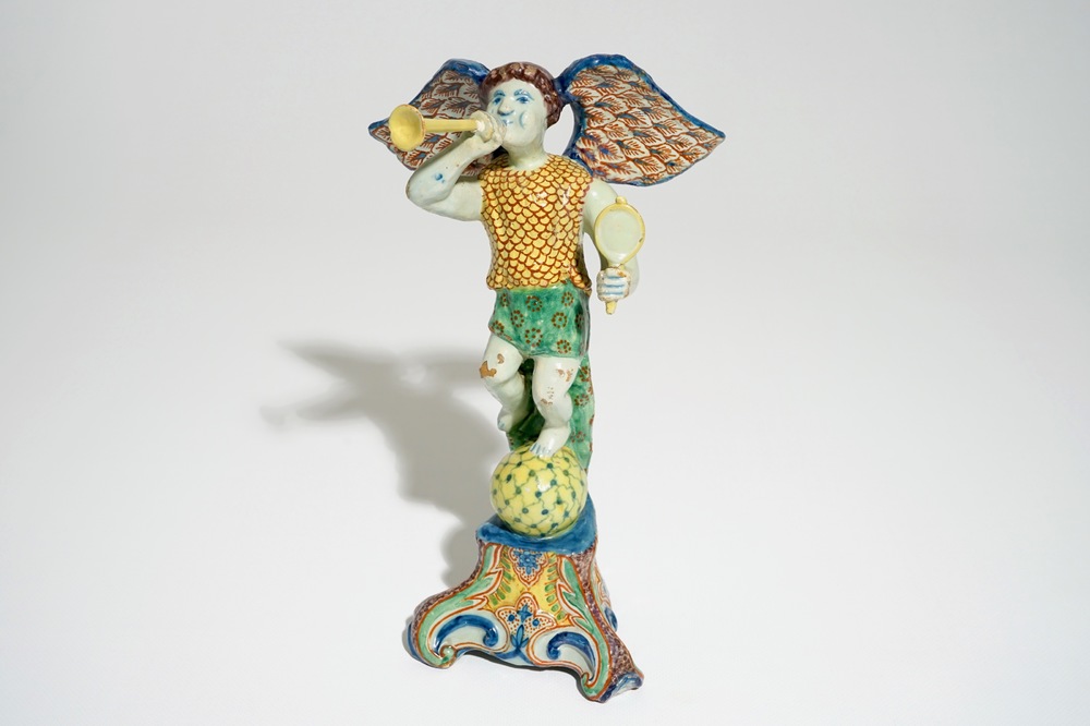 A polychrome Delft style allegorical figure of Fame in the shape of a putto with trumpet, prob. France, 19th C.