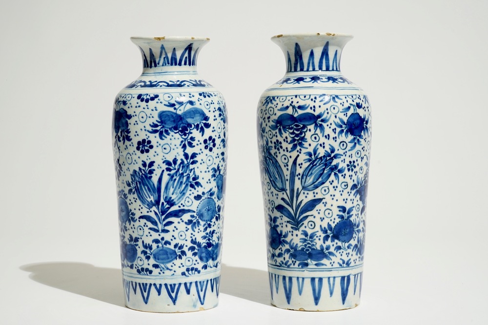 A pair of Dutch Delft blue and white cylindrical vases with tulips and flower scrolls, 17/18th C.