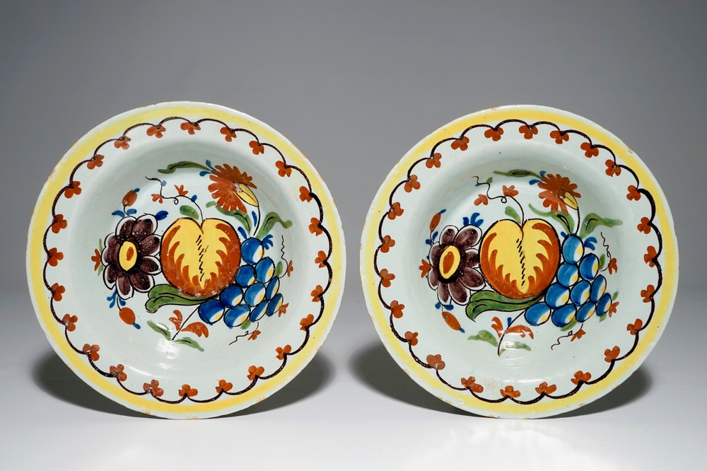 A pair of unusual Dutch Delft deep plates with fruit design, 18th C.