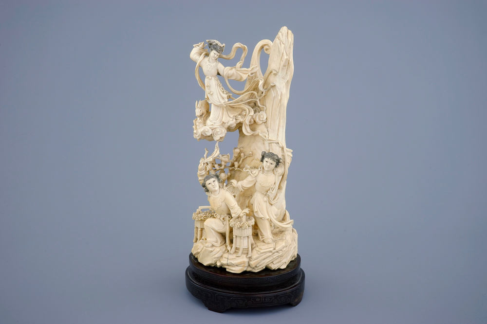 A Chinese carved ivory group of the moon goddess and two girls on a wooden base, 19/20th C.