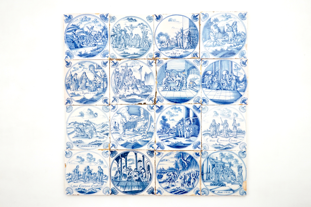 A set of 16 Dutch Delft blue and white biblical tiles with carnation corners, 18th C.