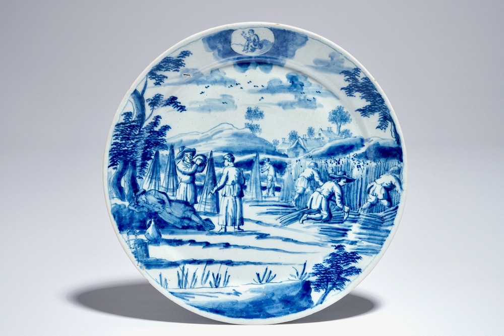 Een Delfts blauw-wit bord met landarbeiders uit de reeks &quot;Sterrenbeelden&quot;, vroeg 18e eeuw